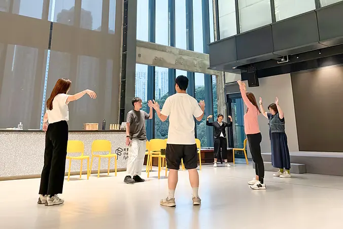 企業員工團體活動中，參加者在明亮場地站成圓圈互動