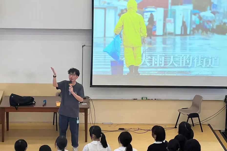 入校活動中，謝偉倫在禮堂向學生分享，屏幕展示下雨天的街道